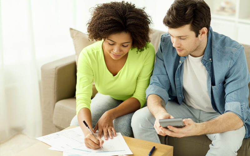 couple sitting on couch planning their budget